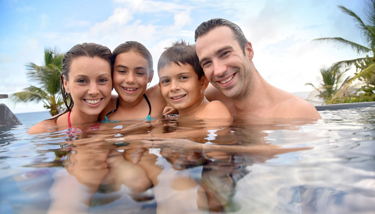 Family of four enjoying swimming-pool